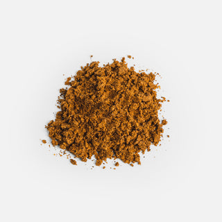 Close-up of the dark brown powder from Herbaly's Wellness Mushroom Complete for Vitality Capsules showing its fine texture